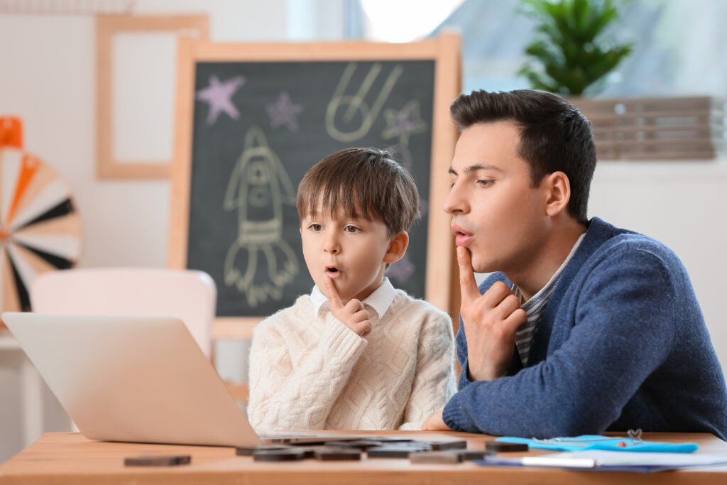 Male speech therapist working on therapeutic services like speech therapy for kids with a male student