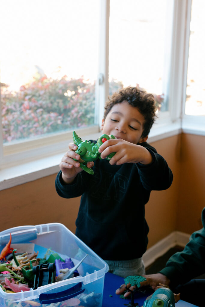 Student playing with a dinosaur at the special education school - Spiritos School