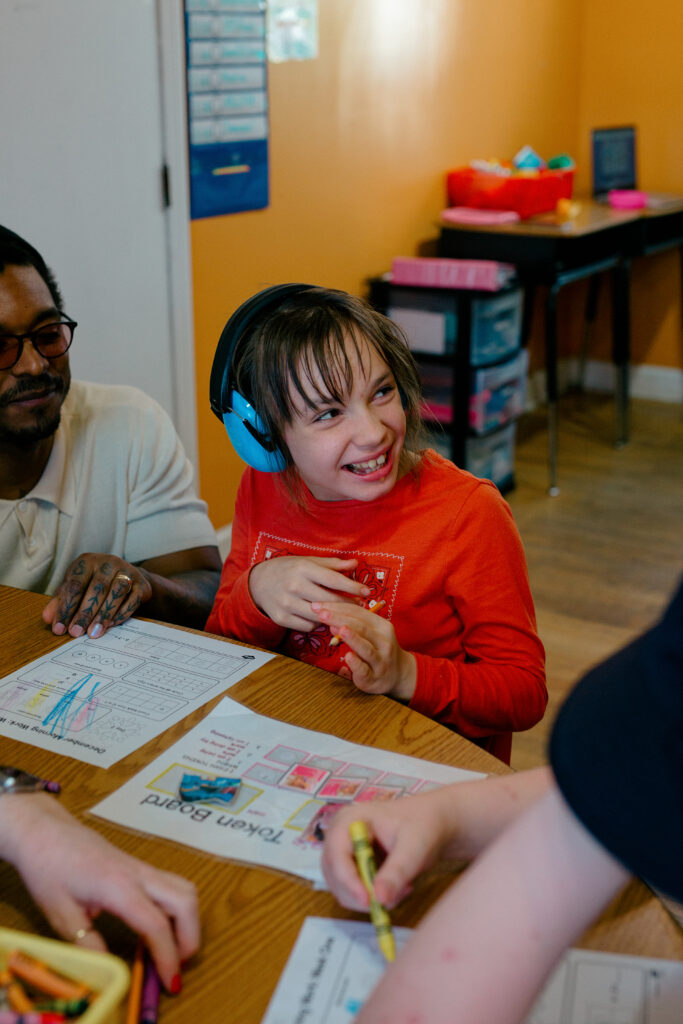 Girl smiling and interacting with teacher at the Spiritos School - a leading special education school