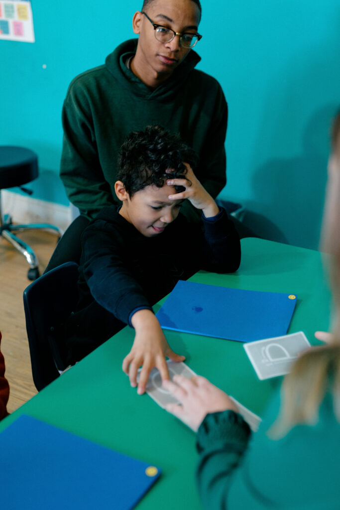 Boy interacting with Spiritos School staff and teacher at a special education school