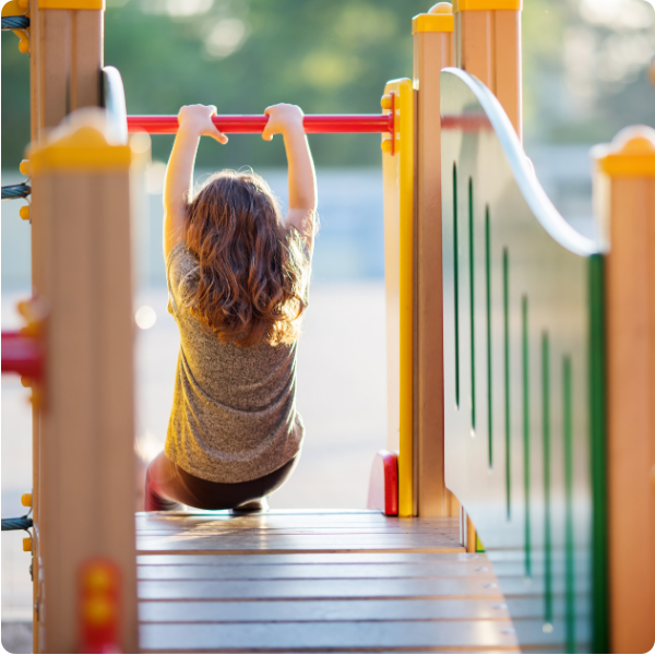 Child playing in playground going down a slide showcasing integrated services offered at Spiritos School