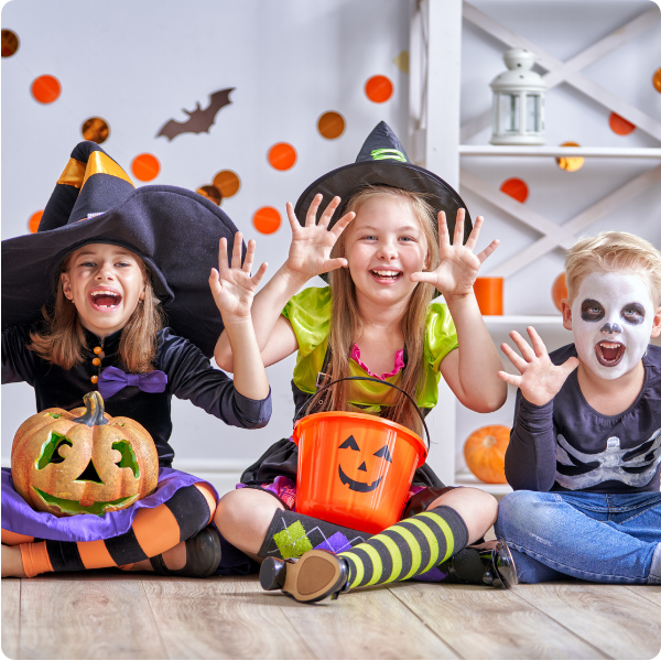 Three children dressed up for halloween as a witch and skeleton showcasing Spiritos School's integrated services