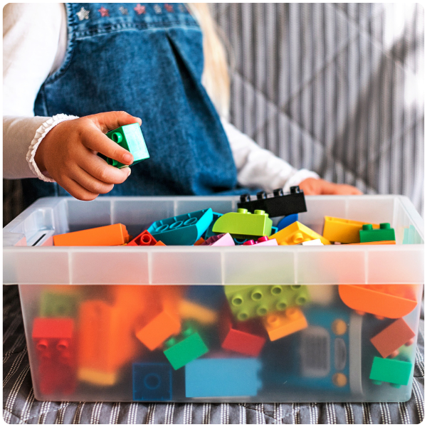 Girl picking up legos and toy blocks learned from functional skills at Spiritos School through integrated services